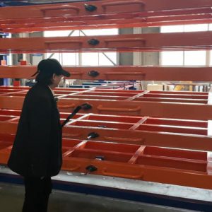 Sheet metal storage rack systems of manufacturing facilities